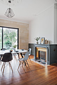 Dining table and chairs in front of fireplace and terrace doors