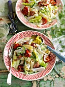 A pasta salad with rigatoni, chicken, tomatoes, lettuce and bacon