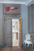 View into vintage-style bathroom through ornate double doors