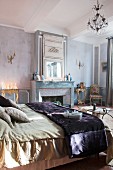 Double bed, mirror on chimney breast and arrangement of candles in sophisticated bedroom