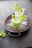 Apple and celery smoothies in glasses on crushed ice