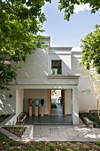 View through rectilinear house with terrace from summery garden