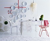 Decorative wall plates and red chair in white, futuristic dining room