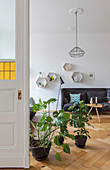 Houseplants on floor in front of open double doors in period apartment