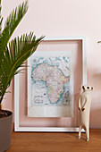 Meerkat figurine in front of framed map of Africa
