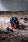 Blueberries and blackberries in a copper measuring cup