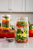 Layered salad in glass with spinach, beans, cheese and egg