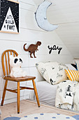 Stuhl mit Vintage Panda-Lampe neben Bett im Dachgeschoss-Kinderzimmer