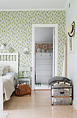 View from bedroom with green-patterned wallpaper into adjacent room