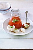Tomato soup in a glass with gnocchi and basil