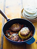 Burger patties with pineapple and peppers in a pan
