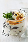 Joghurt mit Chiasamen, Datteln, Nüssen, Fruchtsauce und Minze im Weckglas