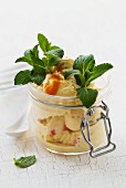 Vanilla and strawberry ice cream with fruit sauce and mint in a mason jar