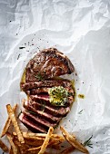 Sliced ribeye steak with herb butter and thin french fries