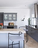 Kitchen counter and bar stools in fitted country-house-style kitchen