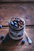 Chocolate granola and yogurt breakfast jar topped with blueberries