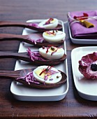 Half boiled eggs with red cabbage on wooden spoons