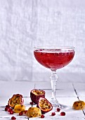 A sparkling wine cocktail with passion fruit and pomegranate