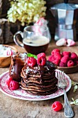 Gestapelte Pancakes mit Schokoladensauce und Himbeeren
