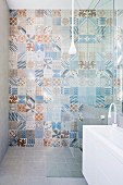 Various wall tiles with retro patterns in pastel blue and brown shades in shower area