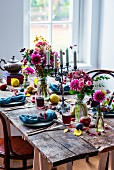 Gedeckter Holztisch herbstlich rustikal dekoriert mit Blumen und Früchten