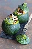 Courgettes stuffed with rice, avocado, pear, pesto and mushrooms