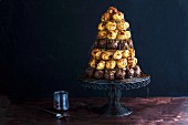 A croquembouche (a French dessert consisting of choux pastry balls bound with caramel threads) on a cake stand