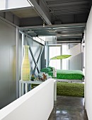 View from hallway with white balustrade wall to glass sliding door and suspended bed