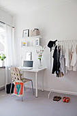 Desk and coat racks in simple room in grey and white