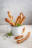 Herb breadsticks in an enamel cup