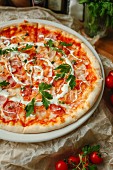 Pizza with tomatoes, ham and pepperoni