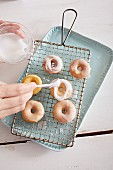 Decorating mini doughnuts with a sugar glaze