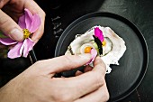 An oyster being decorated with flower petals