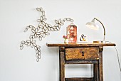 Artistic floral paper decoration on wall next to antique wooden table and retro lamp