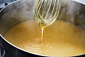 Lemon curd being stirred with a whisk