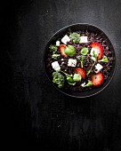A black rice salad with strawberries, feta, broccoli and basil