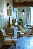 Bust and table lamp on antique cabinet in traditional interior