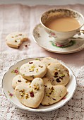 Cookies with pistachios and dried rose petals, served with a cup of coffee