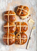 Hot cross buns with butter on a wooden background (Easter baking, England)