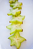 Starfruit in a row on an antique white platter