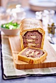 Meat pate baked in a pastry coat with pistachios and cranberries