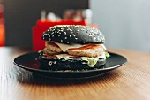 Black burger with cheese, tomatoes and lettuce