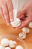 Cleaning white mushrooms with kitchen paper
