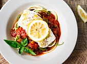 A cod fillet with tomato sauce and zoodles (zucchini noodles)