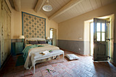 Open door in Mediterranean bedroom with terracotta-tiled floor