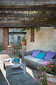 Wicker furniture and wooden table on roofed terrace