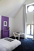 Artistic bedroom with purple accent on wall