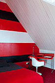 Schlafzimmer unterm Dach mit rot, weiß und schwarz gestreifter Wand