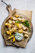 Fried squid with lemon wedges and a herb dip