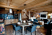 Open-plan kitchen in large interior of rustic log cabin